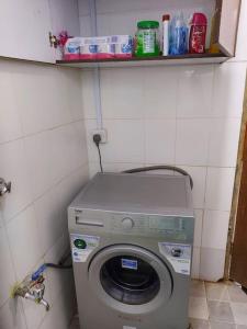uma máquina de lavar roupa num canto de uma casa de banho em A Lovely smart family guest house em Kisii