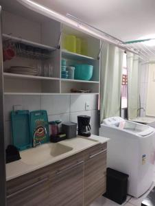 a kitchen with a sink and a refrigerator at Cantinho da Ju in Ipojuca