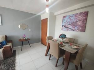 a dining room with a table and chairs and a couch at Cantinho da Ju in Ipojuca