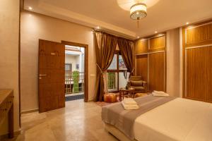 a bedroom with a bed and a chair and a window at Riad Azia in Marrakech