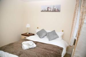 a bedroom with a bed with a towel on it at Stylish beautiful Lodge in Norwich in Norwich