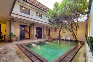 ein Schwimmbad in der Mitte eines Hauses in der Unterkunft Escotel Casa De Luga By Reccoma in Jakarta