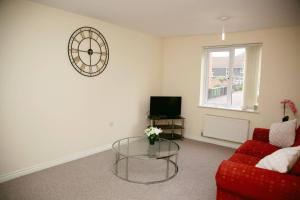 a living room with a red couch and a glass table at Stylish beautiful Lodge in Norwich in Norwich