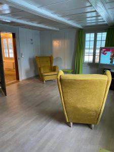 sala de estar con sofá amarillo y TV en B&B tannen124, en Oberburg