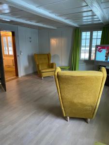 a living room with a yellow couch and a television at B&B tannen124 in Oberburg