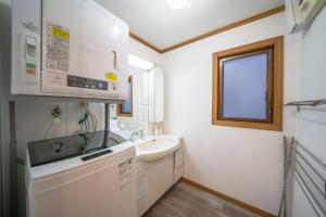 a small white bathroom with a sink and a microwave at Shinjuku / 5 min walk from station ※ projector in Tokyo