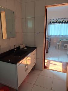 a bathroom with a sink and a door to a room at Paz e descanso Chacara Meu Morrinho in Mairiporã