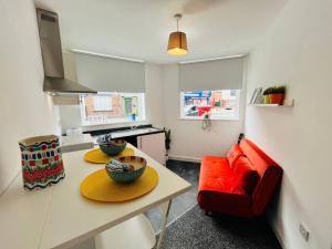 a living room with a table and a red couch at Boutique 1Bed Apt Near the City Centre in Liverpool