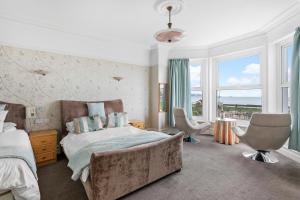a bedroom with a large bed and a large window at Marine Hotel in Paignton