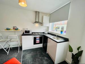 a small kitchen with a sink and a microwave at Boutique 1Bed Apt Near the City Centre in Liverpool