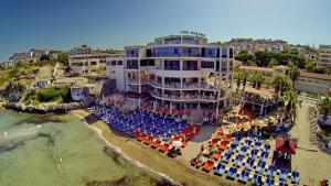 a hotel on the beach with chairs and umbrellas at Ladies Beach Suite Hotel in Kusadası
