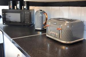 a kitchen counter with a toaster and a toaster oven at Top Spot 2-Bed Apartment Town Centre Train Station Wi-Fi in Colchester