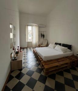een slaapkamer met een bed en een geruite vloer bij LOGICO #35 HOME in Bari