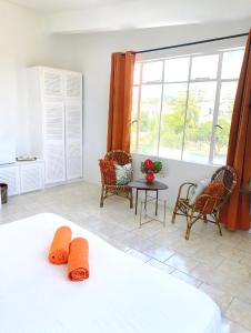 a bedroom with a bed and a table and chairs at Villa Paille en Queue in Flic-en-Flac