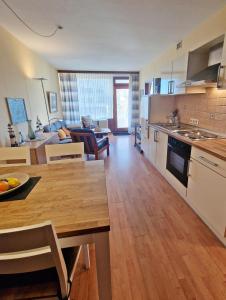 a kitchen and living room with a table and a dining room at Steinwarder 1 - Haus "Seerose" ST1 018 Steinwarder 1 in Heiligenhafen