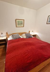a bedroom with a large red bed with two lamps at Steinwarder 1 - Haus "Seerose" ST1 018 Steinwarder 1 in Heiligenhafen