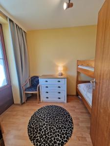 a bedroom with a dresser and a bunk bed at Steinwarder 1 - Haus "Seerose" ST1 018 Steinwarder 1 in Heiligenhafen