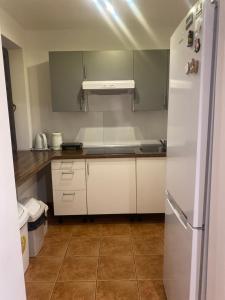 a kitchen with white cabinets and a refrigerator at Agroturystyka Bobrowniki in Szczytna