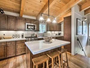 uma cozinha com armários de madeira e um frigorífico branco em Tahoe Oasis - West Shore Chalet with View & Hot Tub! home em Homewood