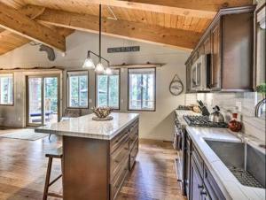 uma grande cozinha com tectos de madeira e uma grande ilha em Tahoe Oasis - West Shore Chalet with View & Hot Tub! home em Homewood