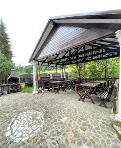 a pavilion with wooden picnic tables and a grill at Casa Ticino Predeal in Predeal +13 photos