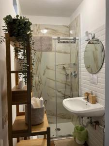 een badkamer met een douche, een wastafel en een spiegel bij LOGICO #35 HOME in Bari