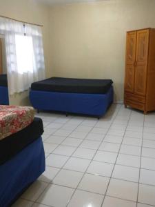 een kamer met 2 bedden en een kast bij Chácara com piscina em Itanhaém in Itanhaém