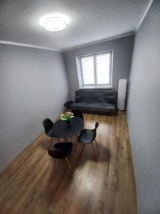 a living room with a table and chairs and a window at Apartament Ogrodzieniec in Ogrodzieniec