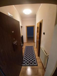 a hallway with a door with a black and white floor at Apartament Ogrodzieniec in Ogrodzieniec