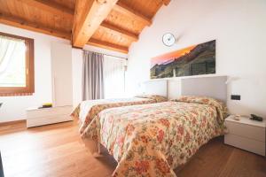 a bedroom with two beds and a clock on the wall at Col Delle Rane in Caerano di San Marco