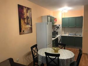 a kitchen with a table and a white refrigerator at Primorski Apartment in Varna City
