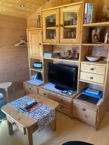 a wooden entertainment center with a tv and a table at Alphütte Bielerhüs in Fiesch