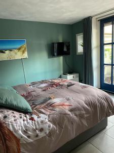 1 dormitorio con 1 cama y TV en la pared en By Onzz, en Kamperland