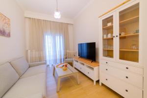 a living room with a couch and a tv at New modern 2nd floor apartment in Thessaloniki