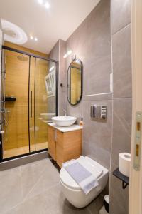 ein Bad mit einem WC, einem Waschbecken und einer Dusche in der Unterkunft New modern 2nd floor apartment in Thessaloniki