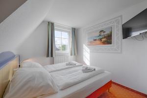 een wit bed in een kamer met een raam bij Seehotel Düne in Graal-Müritz