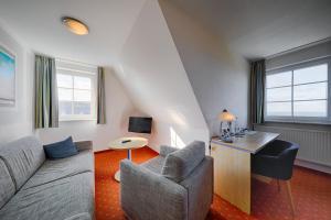 een woonkamer met een bank en een tafel bij Seehotel Düne in Graal-Müritz