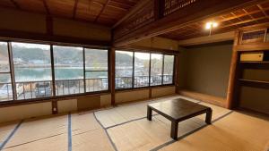 a room with a table in a room with windows at すくもBOX in Sukumo