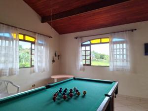 einen Billardtisch in einem Zimmer mit Fenstern in der Unterkunft Chácara Iris in Pinhalzinho