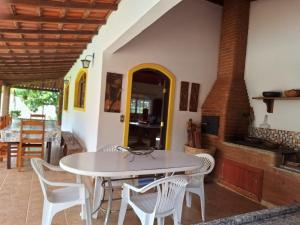 una sala da pranzo con tavolo e sedie bianchi di Chácara Iris a Pinhalzinho