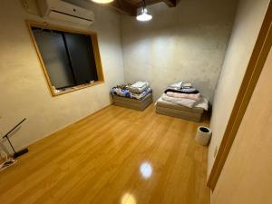 a room with two beds and a flat screen tv at すくもBOX in Sukumo