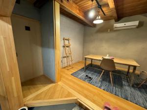 a room with a table and a chair and a ladder at すくもBOX in Sukumo