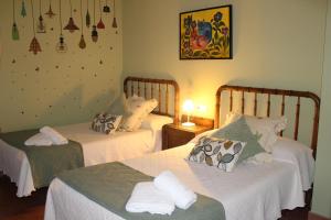 um quarto com 2 camas e lençóis brancos em La Cuadra em Cabornera