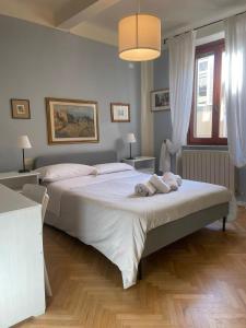 een slaapkamer met een groot bed en handdoeken bij EstateGuard Group - Prestige Rooms Lucca City Center in Lucca