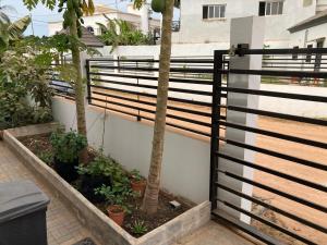 una valla con árboles y plantas junto a un edificio en Palm Villas Estate, en Bijilo