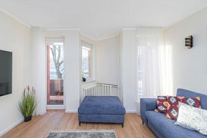 a living room with a blue couch and a window at Riverfront 1BD Old Town Apartment by Hostlovers in Kaunas