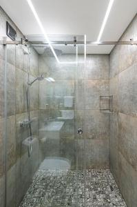 a bathroom with a shower with a glass door at Riverfront 1BD Old Town Apartment by Hostlovers in Kaunas