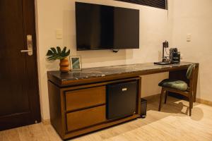 a desk with a flat screen tv on top of it at Casa Continental Hotel Boutique & Suites - Adults Only in Mérida