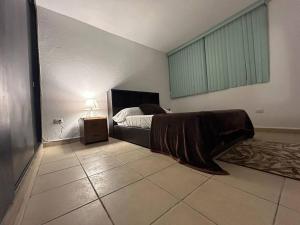 a bedroom with a bed and a lamp on a tiled floor at Departamento Harmony Xalapa in Xalapa