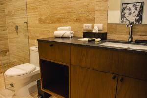 a bathroom with a sink and a toilet and a shower at Casa Continental Hotel Boutique & Suites - Adults Only in Mérida